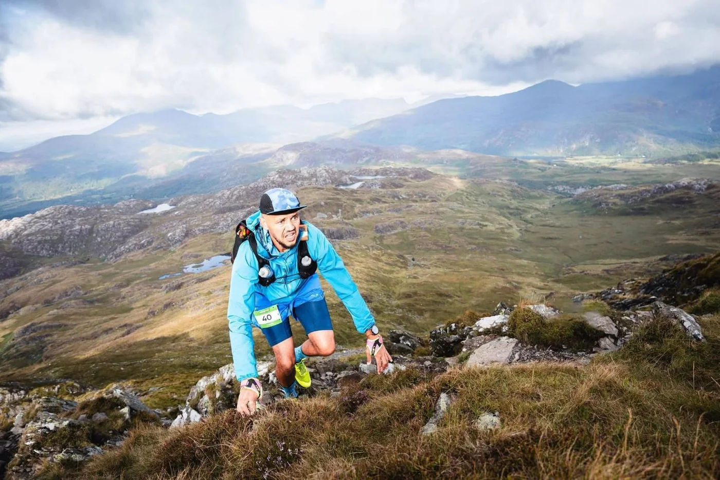 Daniel Dublin climbing a rocky mountainside in a blue jacket, race number 40 visible