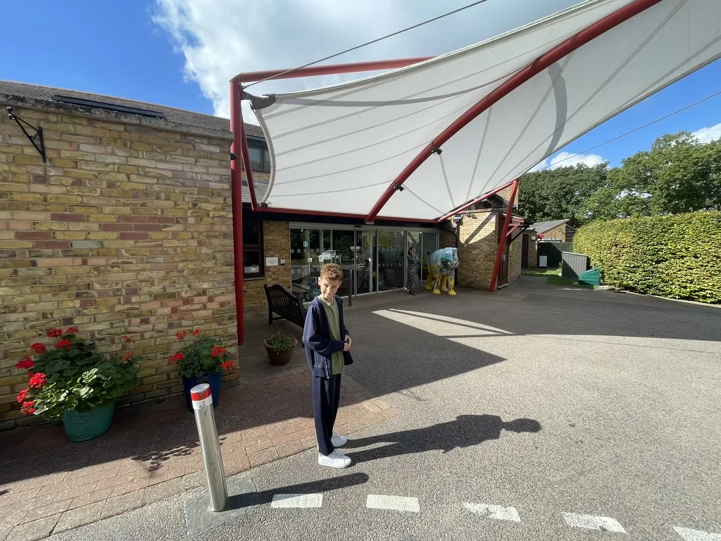 Dexter standing outside the entrance to Little Havens Children's Hospice under a white canopy